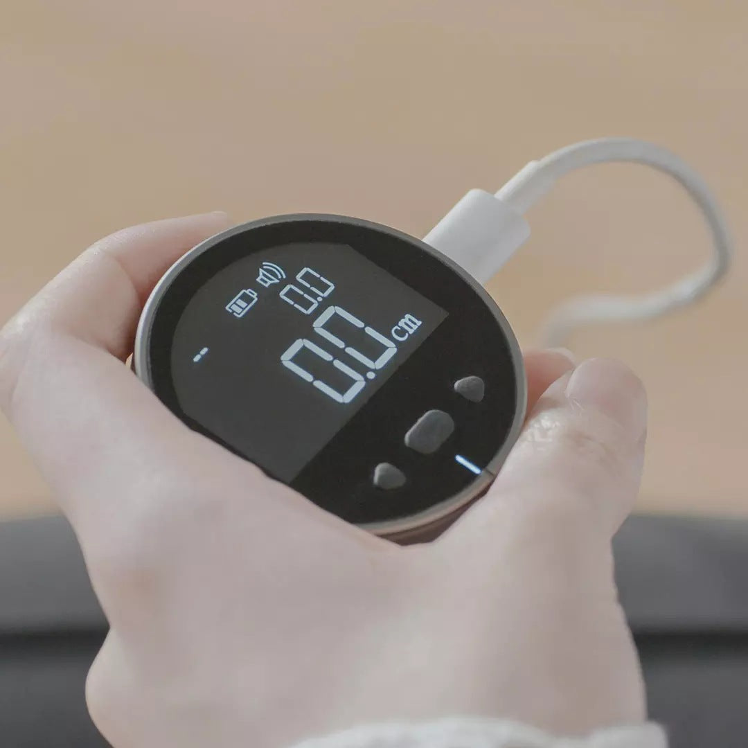 Mètre ruban numérique intelligent en charge USB, tenu dans la main
