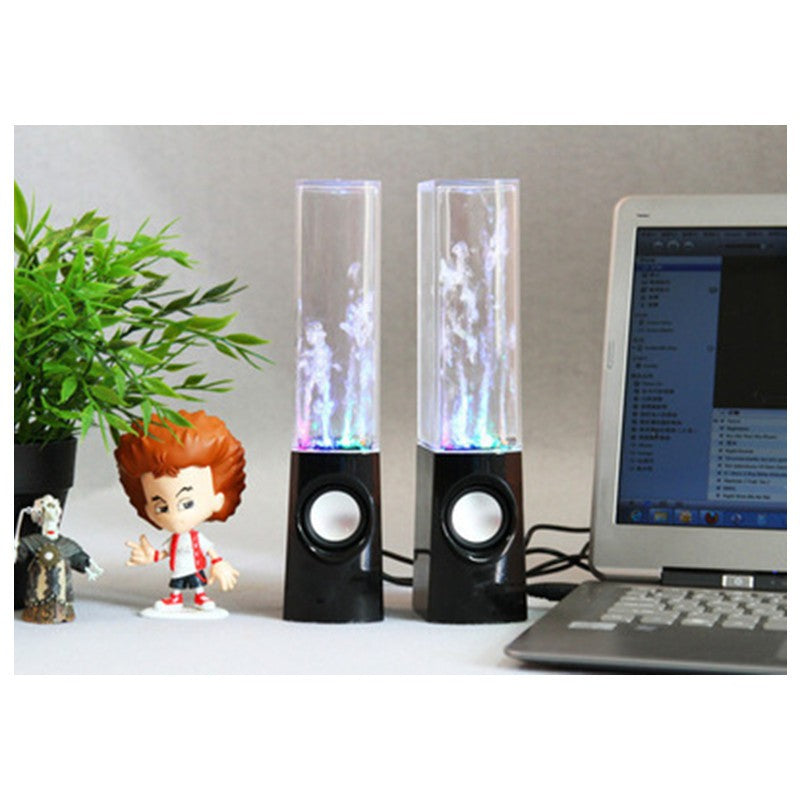 Enceinte Bluetooth fontaine dansante LED posée sur un bureau près d'un ordinateur portable